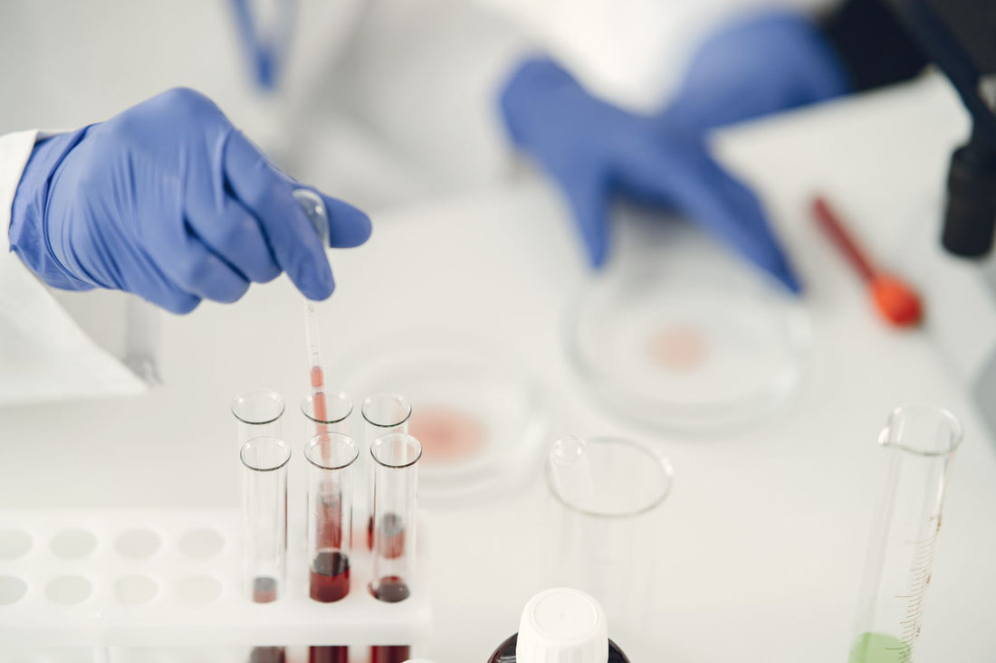 Persona con guantes usando una pipeta para dosificar muestra líquida en tubos de ensayo